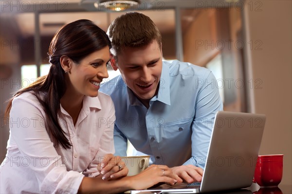 Couple looking at laptop. Photo : db2stock