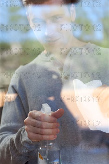 Man cleaning window pane. Photo : db2stock