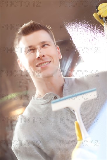 Man cleaning window pane. Photo : db2stock