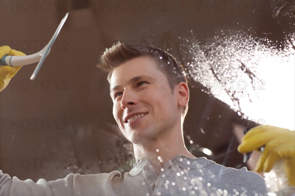 Man cleaning window pane. Photo : db2stock