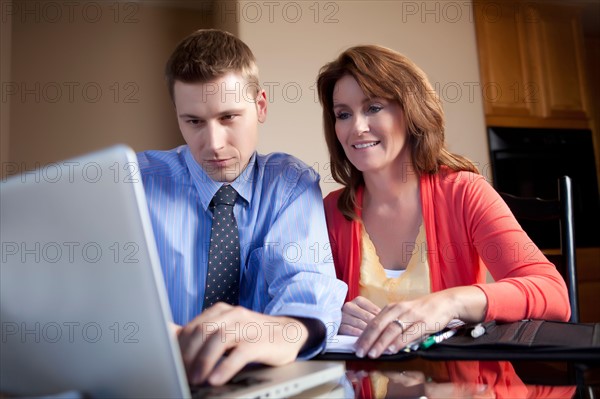 Couple looking at laptop. Photo : db2stock