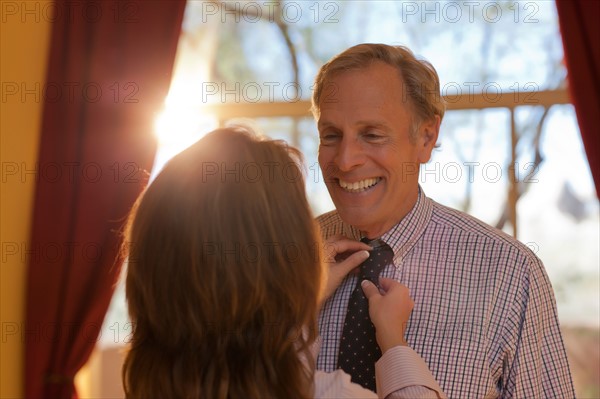 Woman helping man get dressed. Photo : db2stock