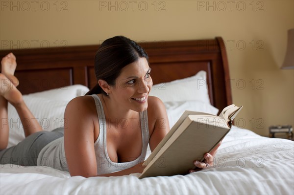 Woman reading on bed. Photo : db2stock