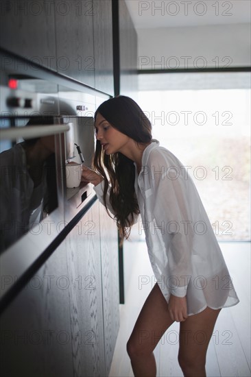 Young woman making coffee. Photo : Mark de Leeuw