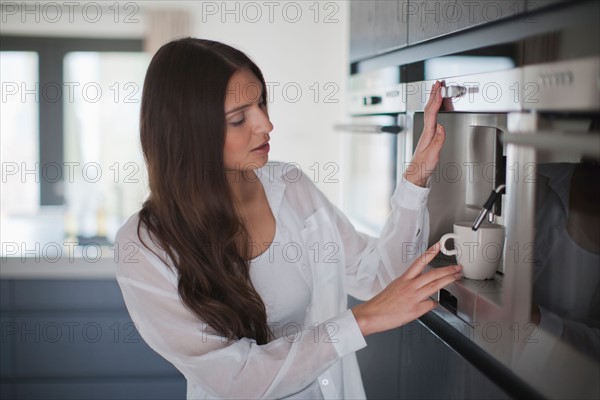 Young woman making coffee. Photo : Mark de Leeuw