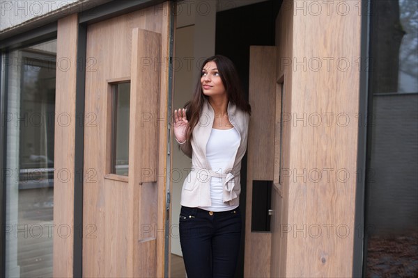 Woman standing in doorway. Photo : Mark de Leeuw