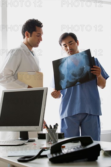 Doctors looking at x-ray image. Photo : Rob Lewine