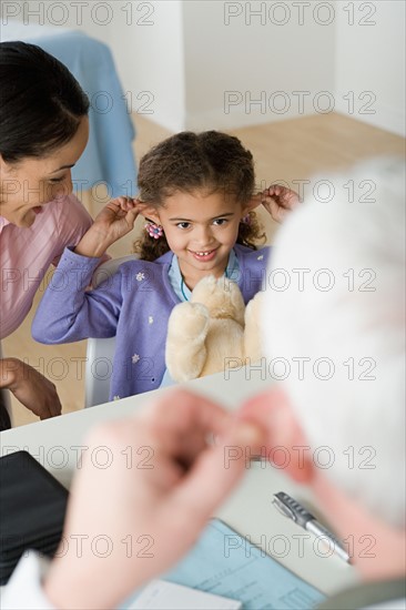 Girl (10-11) with mother in doctor's office. Photo : Rob Lewine