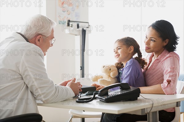 Girl (10-11) with mother talking to doctor. Photo : Rob Lewine