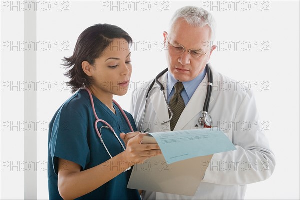 Two doctors reading document. Photo : Rob Lewine