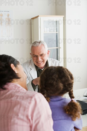 Girl (10-11) with mother talking to doctor. Photo : Rob Lewine