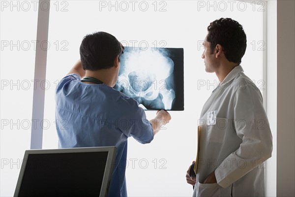 Two doctors looking at x-ray image. Photo : Rob Lewine