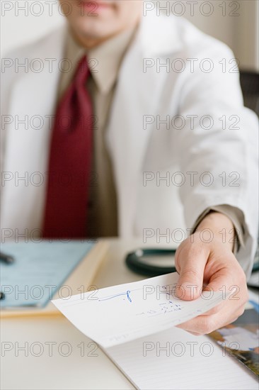Doctor holding prescription. Photo : Rob Lewine