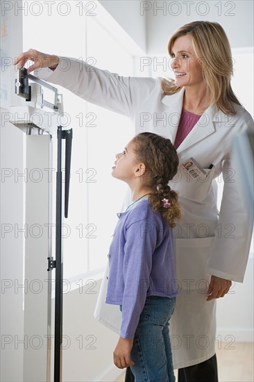 Doctor weighting girl (10-11). Photo : Rob Lewine