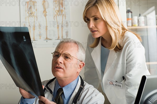 Two doctors looking at x-ray image. Photo : Rob Lewine