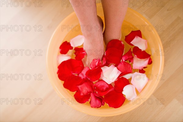 Woman soaking feet in water with rose petals. Photo : Rob Lewine