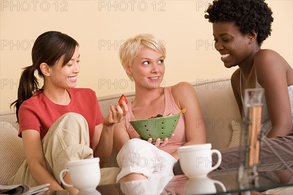 Three girlfriends relaxing on sofa. Photo : Rob Lewine