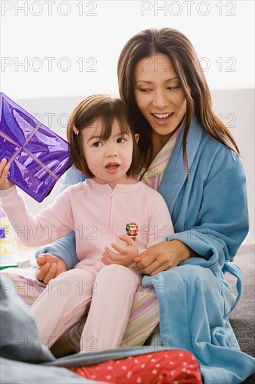 Mother with daughter unwrapping christmas gifts. Photo : Rob Lewine