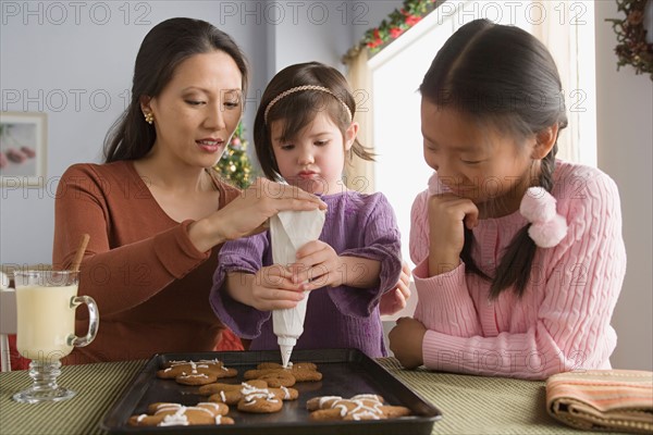 Mother and daughters (10-11) preparing cakes. Photo : Rob Lewine