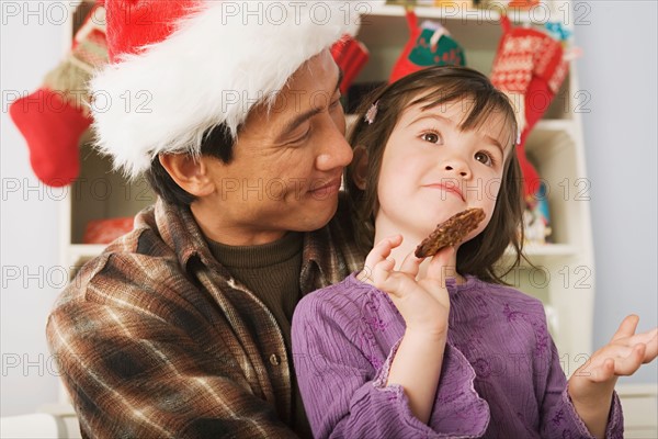 Girl and father wearing santa hat. Photo : Rob Lewine