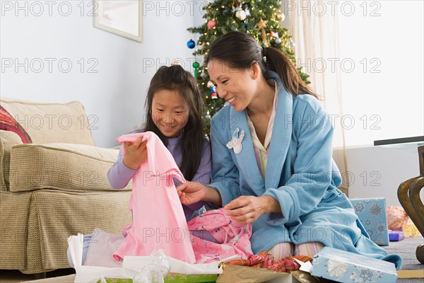 Mother and daughter unwrapping christmas gifts. Photo : Rob Lewine