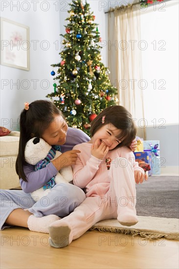 Two sisters (10-11) in front of christmas tree. Photo : Rob Lewine