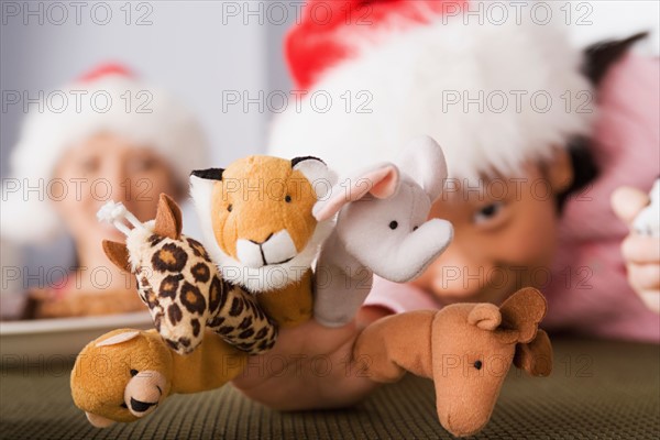 Girl wearing Santa hat playing with finger puppets. Photo : Rob Lewine