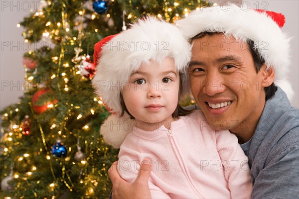 Portrait of father and daughter at Christmas tree. Photo : Rob Lewine