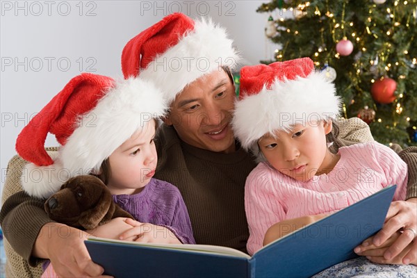 Father reading to two daughters (10-11). Photo : Rob Lewine