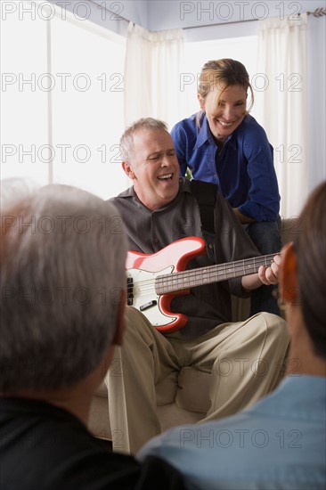 Group of friends having fun with guitar. Photo : Rob Lewine