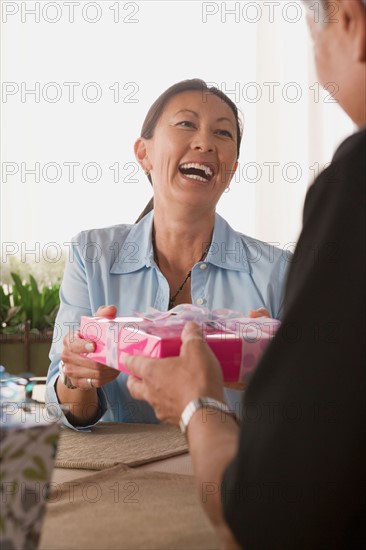 Laughing woman receiving present. Photo : Rob Lewine