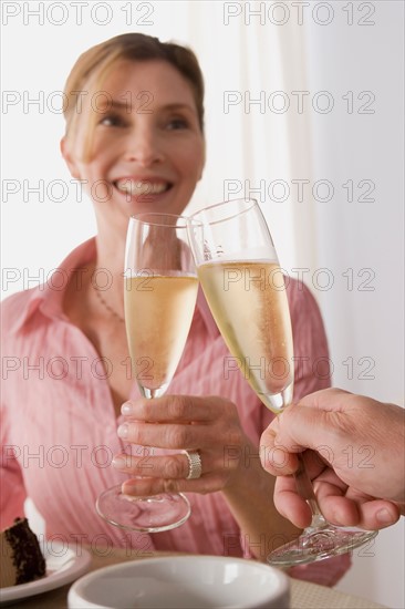 Woman toasting with glass of champagne. Photo : Rob Lewine
