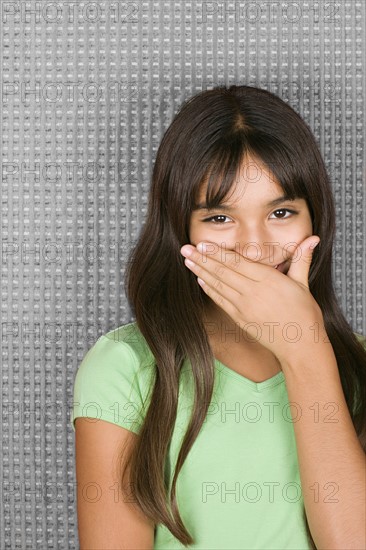 Laughing teenage girl with hands over mouth. Photo : Rob Lewine