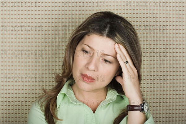 Studio portrait of senior woman with headache. Photo : Rob Lewine