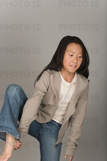 Studio portrait of teen (16-17) girl standing on one leg. Photo : Rob Lewine