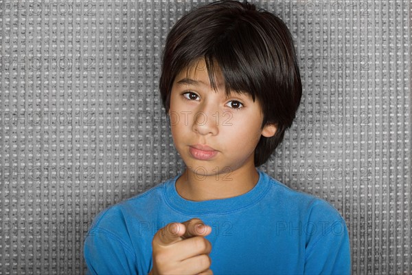 Studio portrait of young man pointing at camera. Photo : Rob Lewine