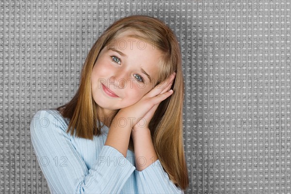 Studio portrait of teen (16-17) girl resting head on hands. Photo : Rob Lewine