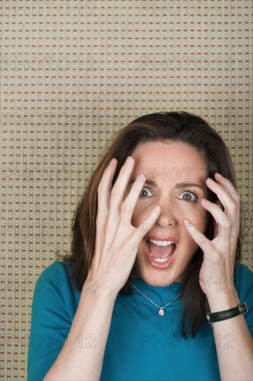 Studio portrait of mature woman screaming. Photo : Rob Lewine