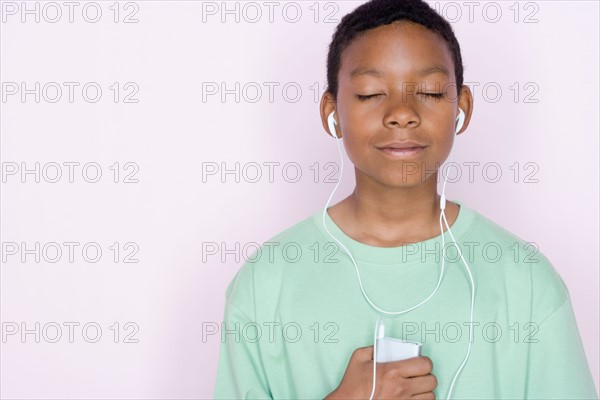 Studio portrait of teenage boy listening to music. Photo : Rob Lewine