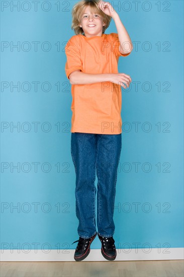 Studio portrait of teenage (16-17) boy jumping. Photo : Rob Lewine