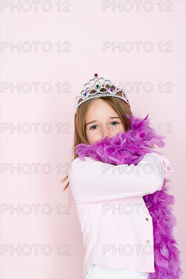 Studio shot portrait of teenage girl in diadem and feather boa shawl, waist up. Photo : Rob Lewine