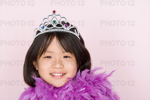 Studio shot portrait of teenage girl in diadem and feather boa shawl, head and shoulders. Photo : Rob Lewine