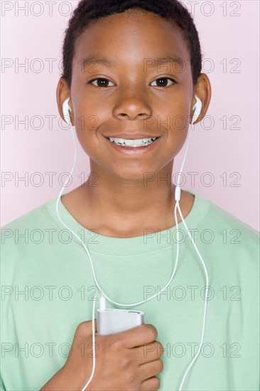 Studio shot portrait of young man with mp3 player, head and shoulders. Photo : Rob Lewine