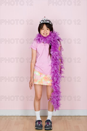 Studio shot portrait of teenage girl in diadem and feather boa shawl, full length. Photo : Rob Lewine