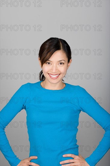 Studio shot portrait of mature woman with hands on hip, waist up. Photo : Rob Lewine