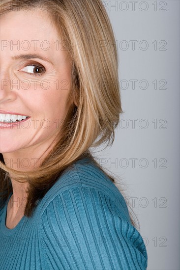 Studio shot portrait of mature woman looking away, head and shoulders. Photo : Rob Lewine