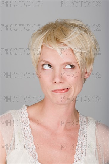 Studio shot portrait of mid adult woman blowing hair over face, close-up. Photo : Rob Lewine