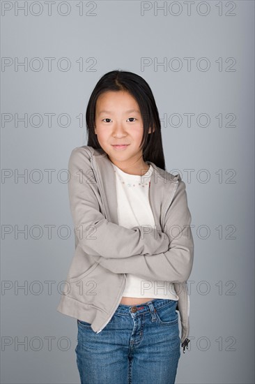 Studio shot portrait of teenage girl with arms crossed, waist up. Photo : Rob Lewine