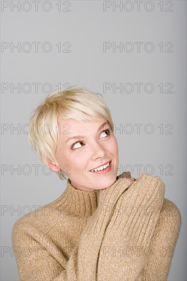 Studio shot portrait of young woman scratching head, head and shoulders. Photo : Rob Lewine