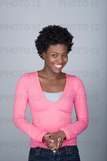 Studio shot portrait of mid adult woman with hands clasped, waist up. Photo : Rob Lewine